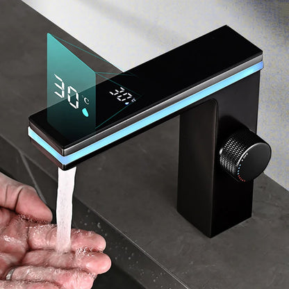 Modern black faucet with digital temperature display dispensing water into a hand.