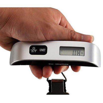 Digital luggage scale held by a hand with a white background