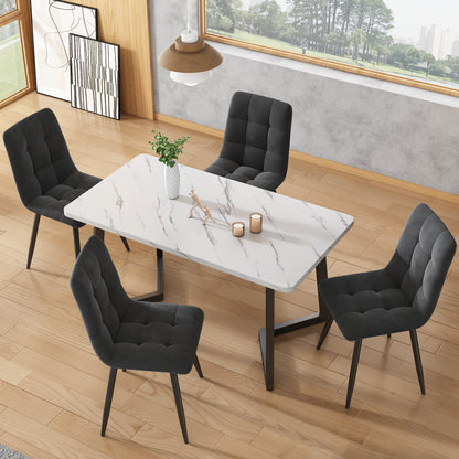 Dining room setup with a marble table and black chairs in a modern interior.