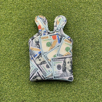Small pouch with dollar bill pattern on a green grass background