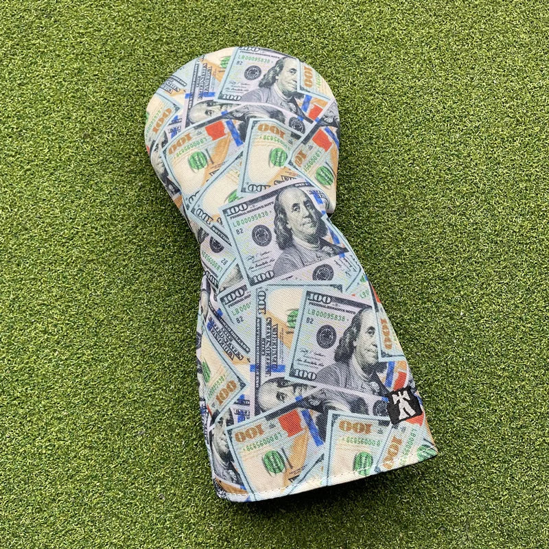 Golf club head cover with dollar bill design on a green grass background