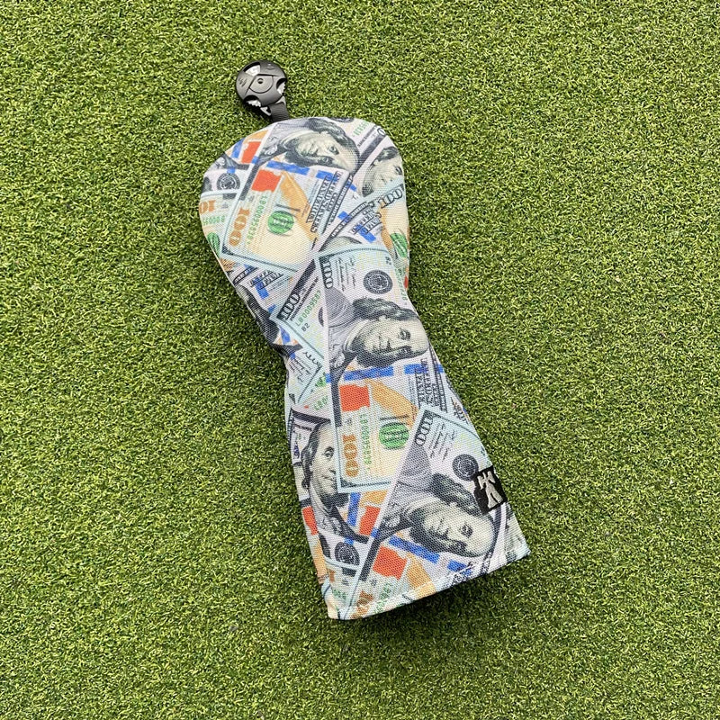 Golf club head cover with dollar bill design on a green surface