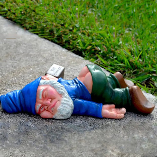 Gnome figurine lying on the ground with a smartphone in its mouth