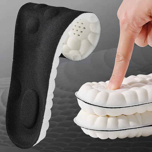 Black and white shoe insert with a hand pressing down on it against a gray background