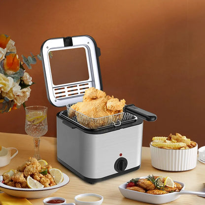 Small deep fryer with fried food on a table with a drink and snacks.