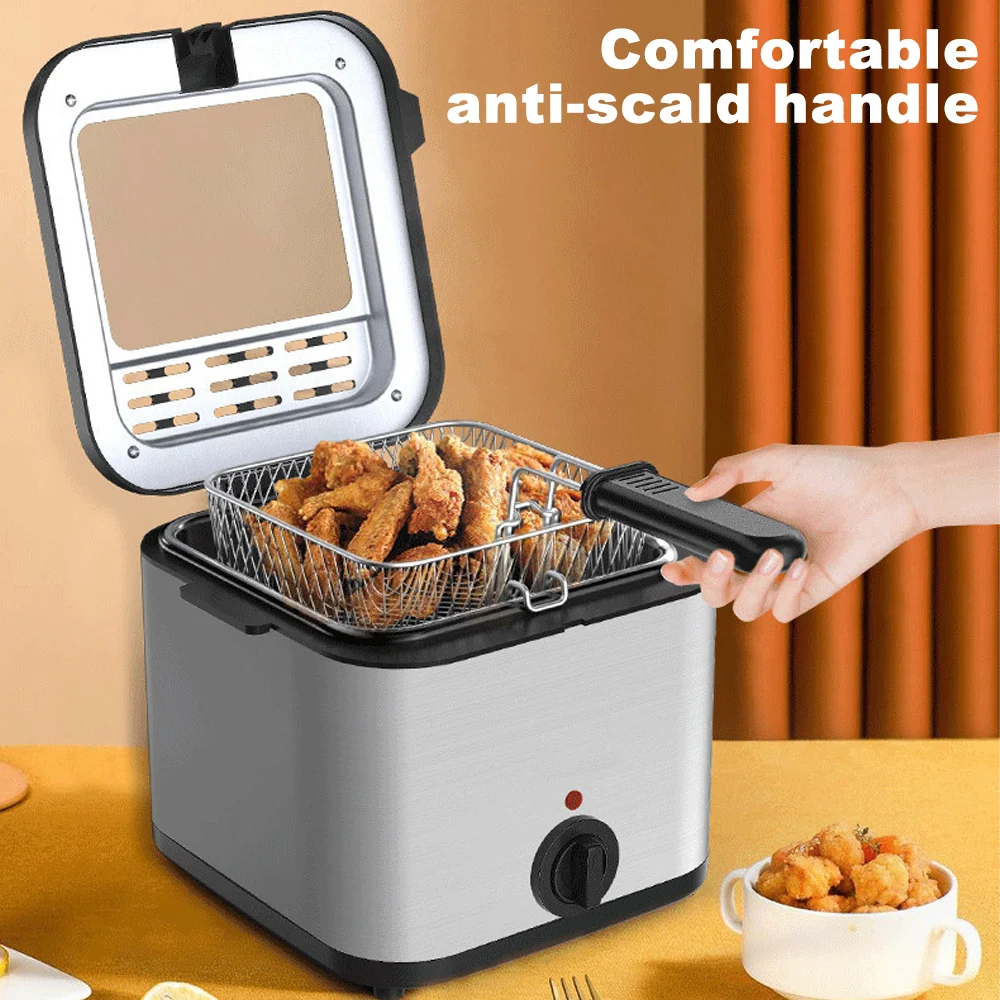 Small deep fryer with a handle holding fried food, placed on a table.