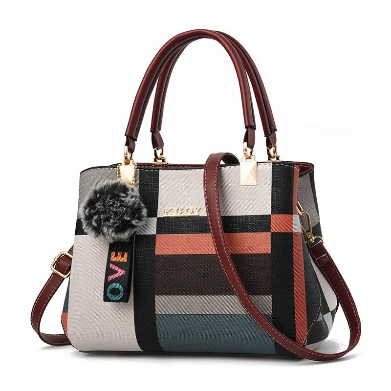 Multicolored checkered handbag with a 'KUJO' tag and pom-pom on a white background