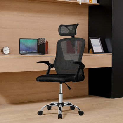 Black office chair with headrest in front of a wooden desk with a laptop and monitor.