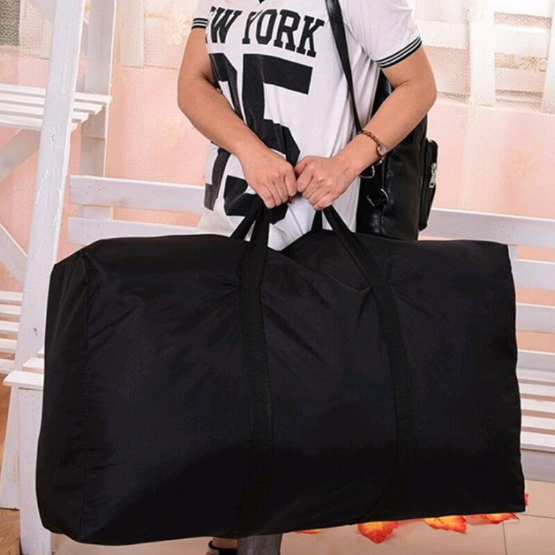 Person holding a large black duffel bag in a room with white chairs and a striped wall.