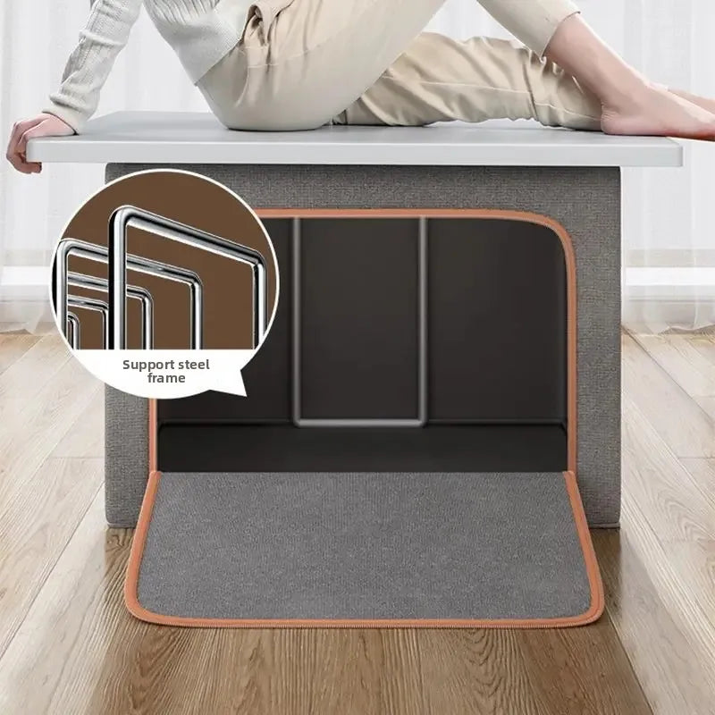 Gray cushioned ottoman with a person sitting on it, showing support steel frame detail.