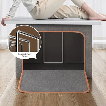 Gray cushioned ottoman with a person sitting on it, showing support steel frame detail.