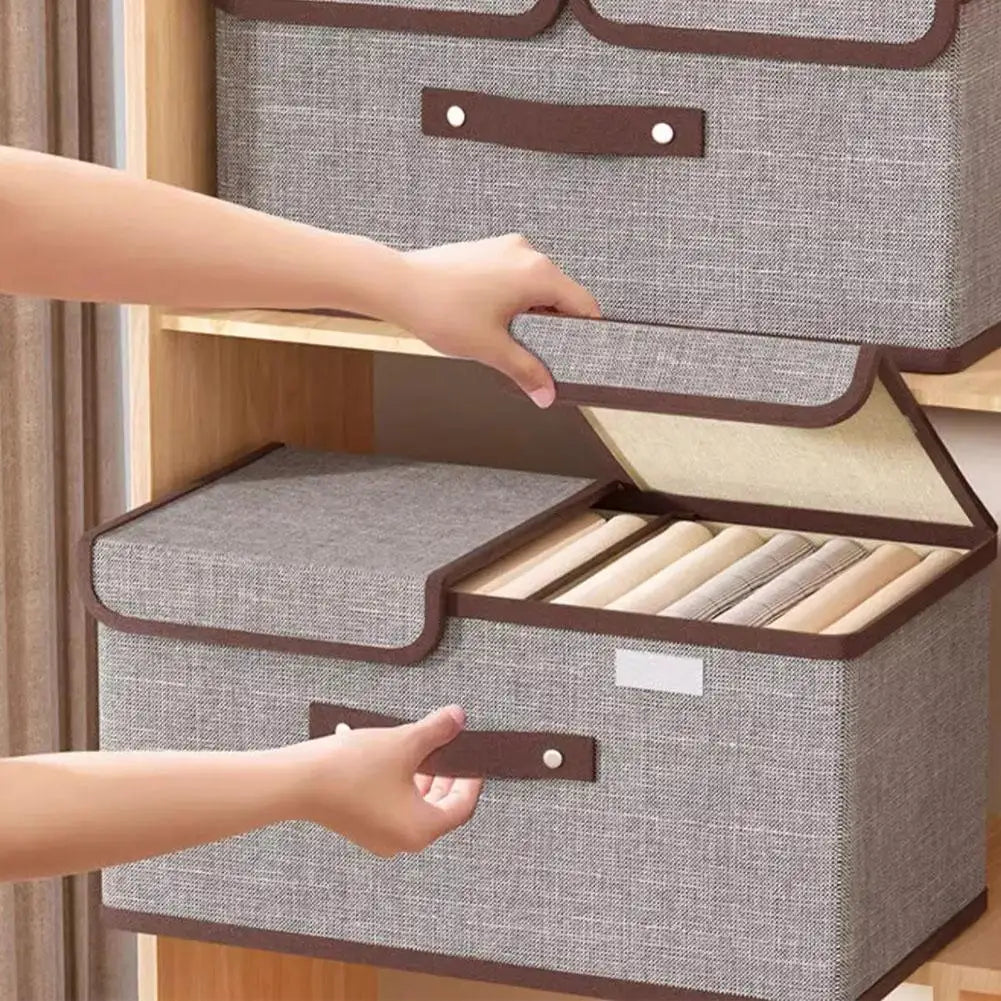 Gray storage box with brown handles and trim, opened to reveal rolled-up items inside.