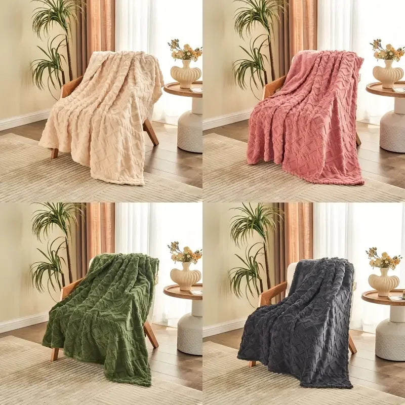 Four different colored blankets draped over a chair in a room with plants and a table.