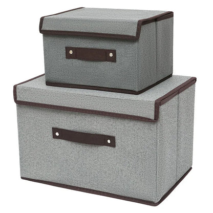 Two gray storage boxes with brown handles on a white background