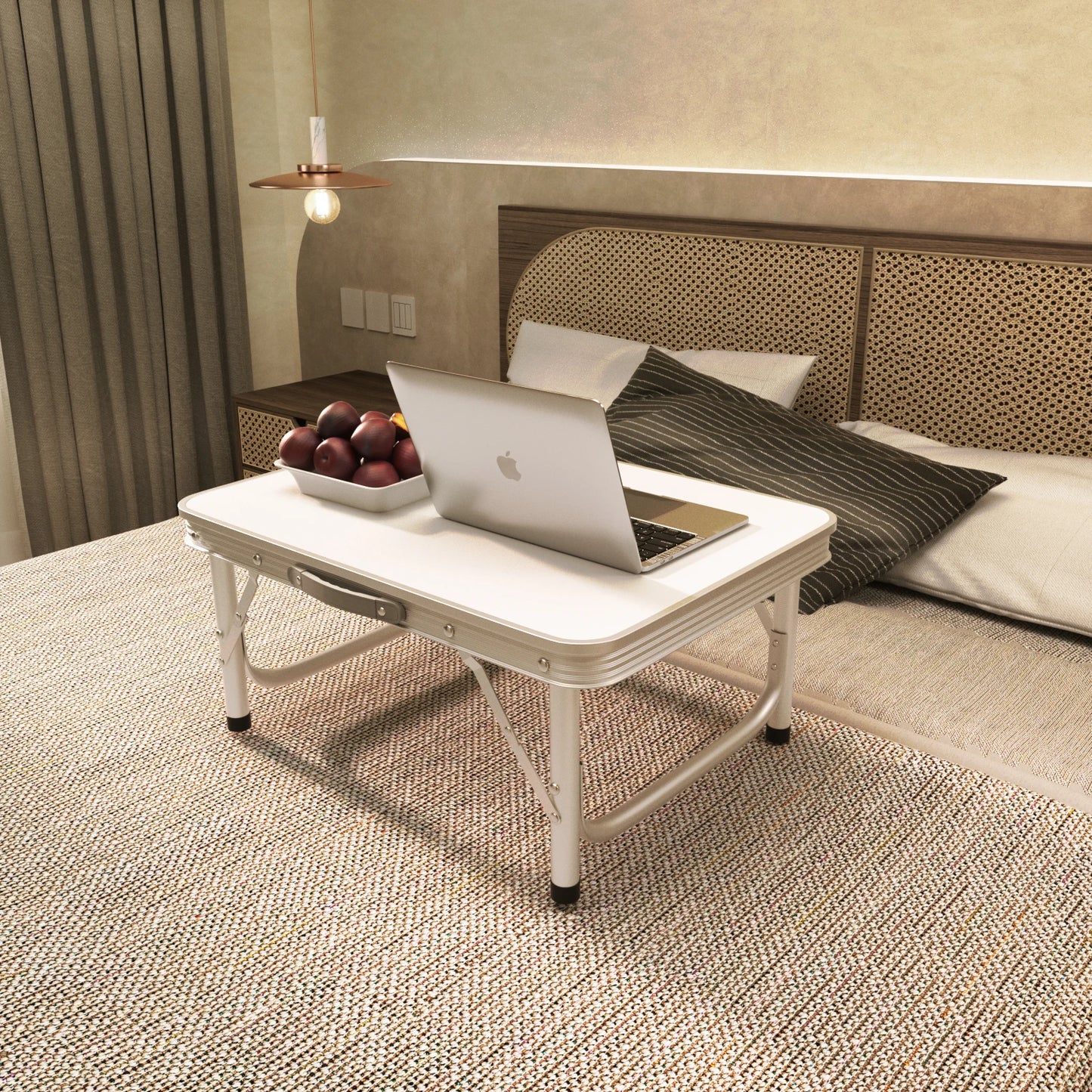 Portable folding table with laptop on a bed in a bedroom setting