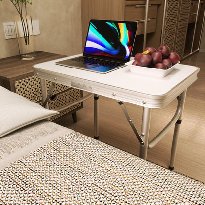 Foldable desk with laptop and fruit on a wooden floor