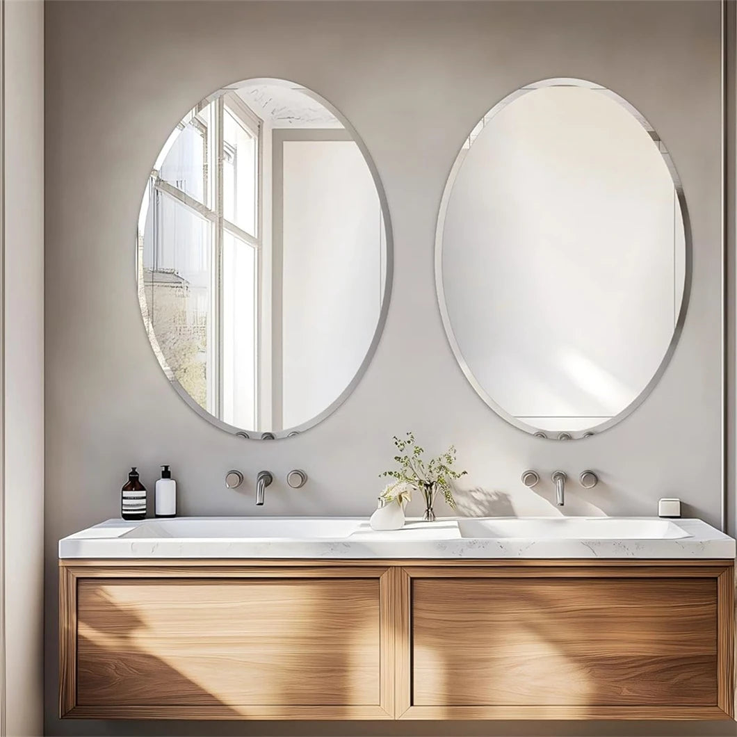 Bathroom vanity with two oval mirrors, wooden cabinets, and white countertop.