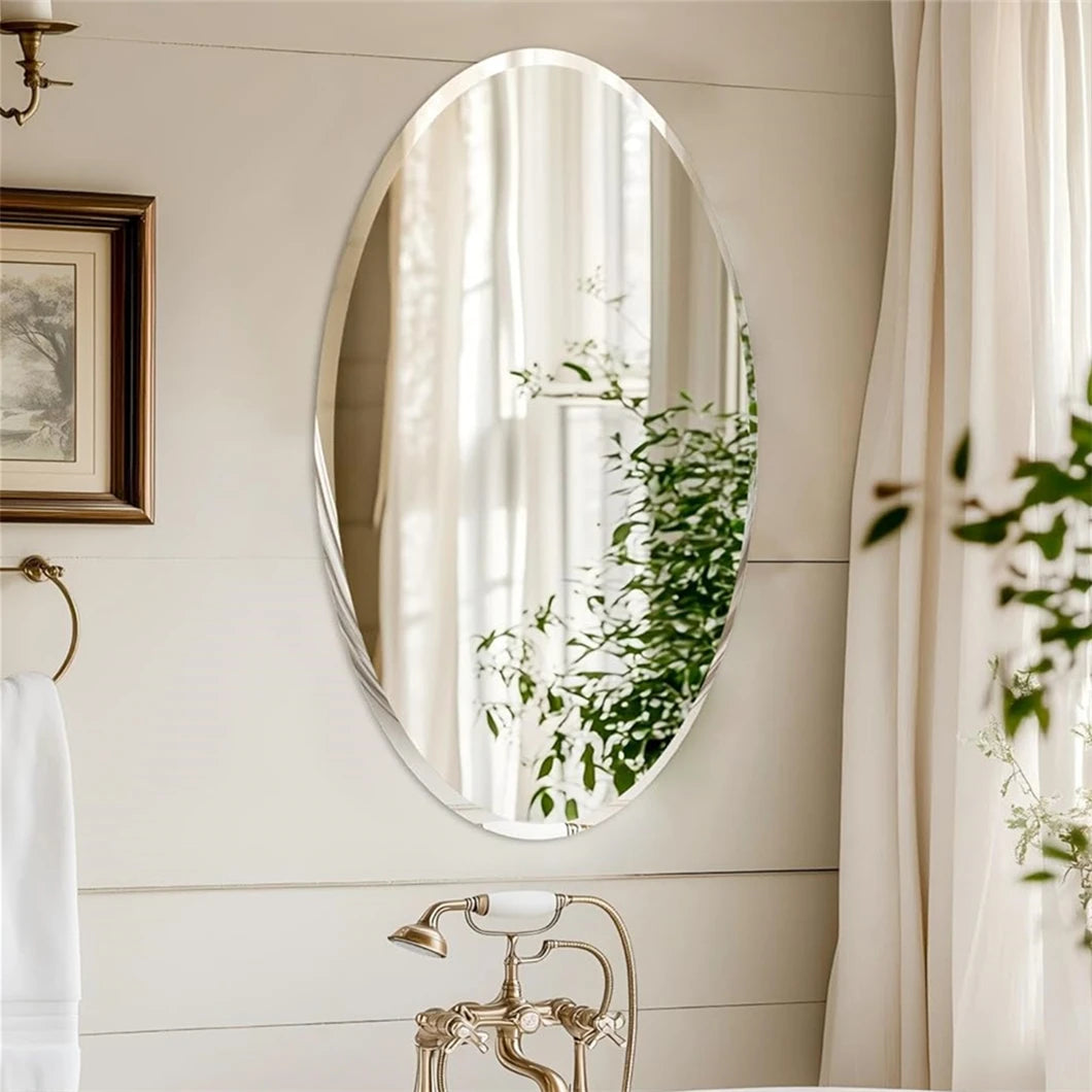 Bathroom with oval mirror reflecting greenery, framed artwork, and towel rack.