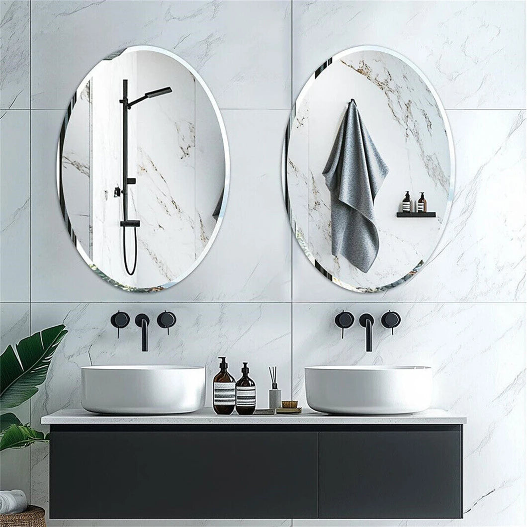 Modern bathroom with two oval mirrors, black fixtures, and white sinks.