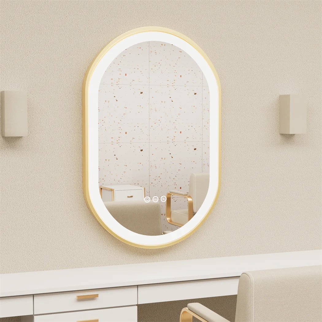 Oval-shaped mirror with gold frame on a beige wall