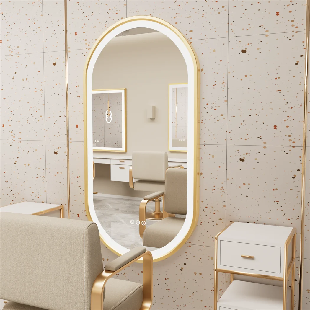 Oval-shaped mirror with gold frame in a room with beige chairs and furniture.