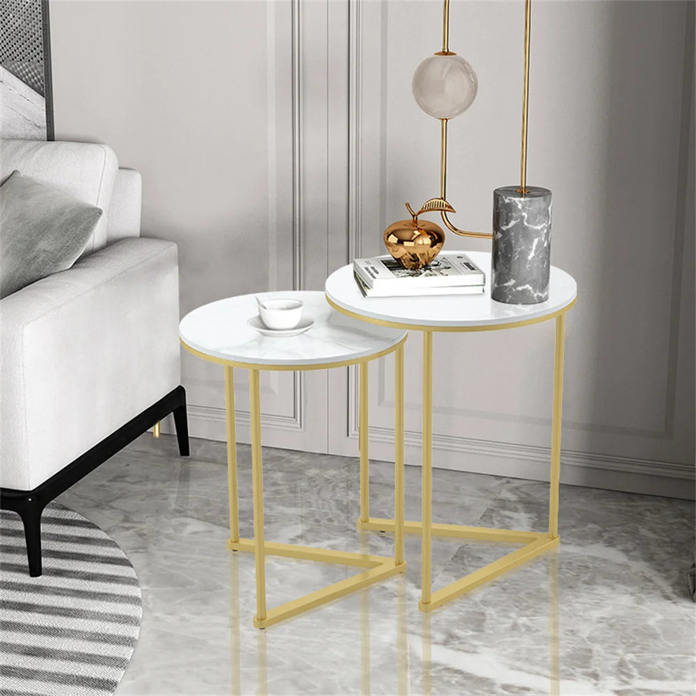 Two round side tables with gold frames in a living room setting.