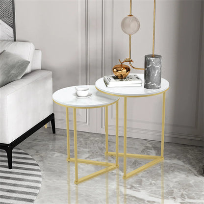 Two round side tables with gold frames in a living room setting.