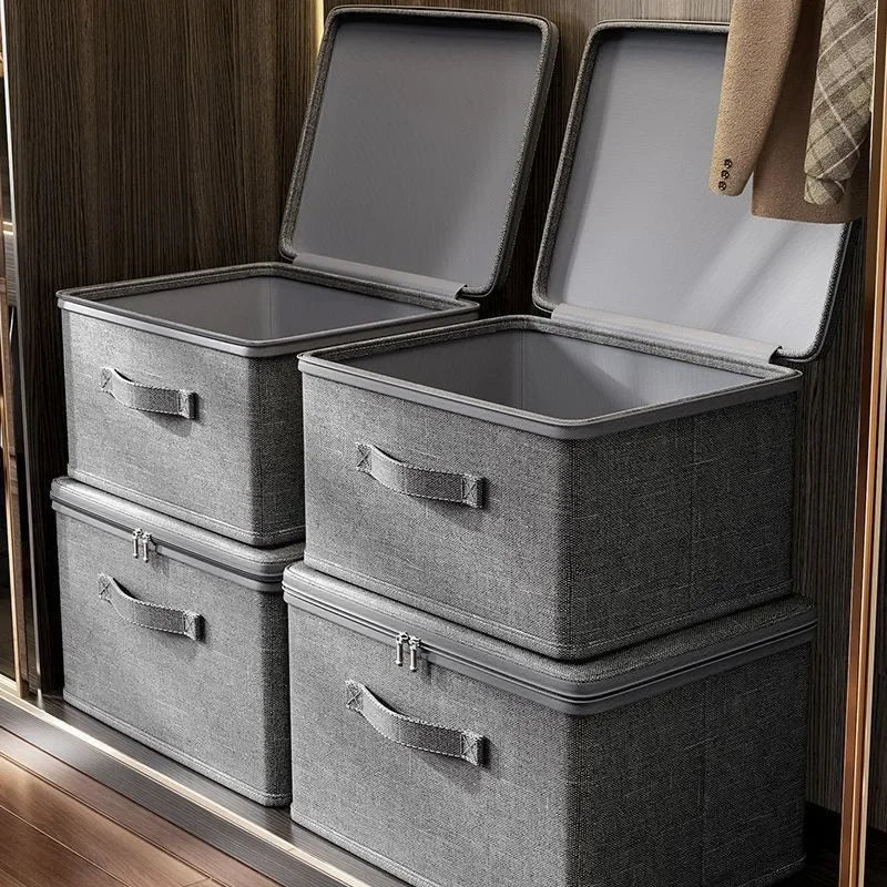 Set of gray storage boxes with lids on a wooden surface.