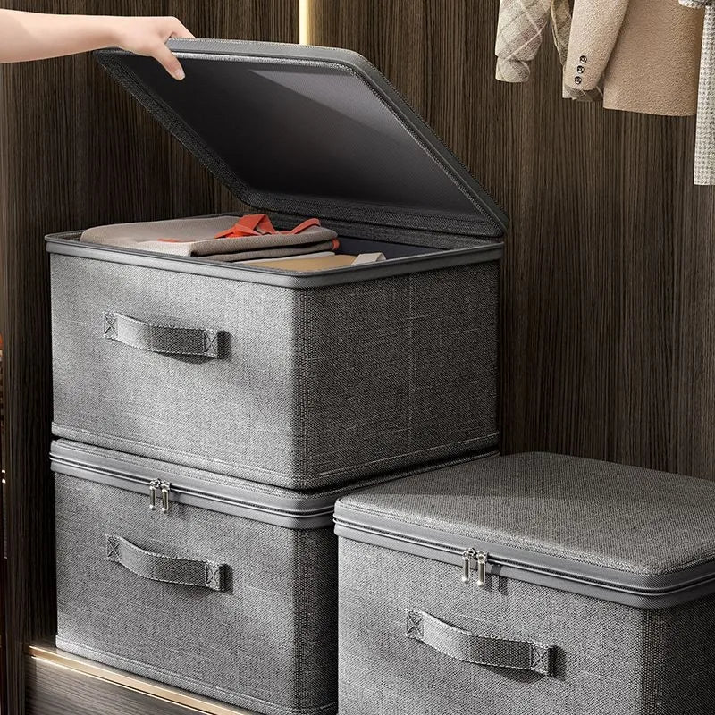 Gray storage boxes with lids being opened on a wooden floor.