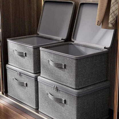 Set of gray storage boxes with lids on a wooden surface.