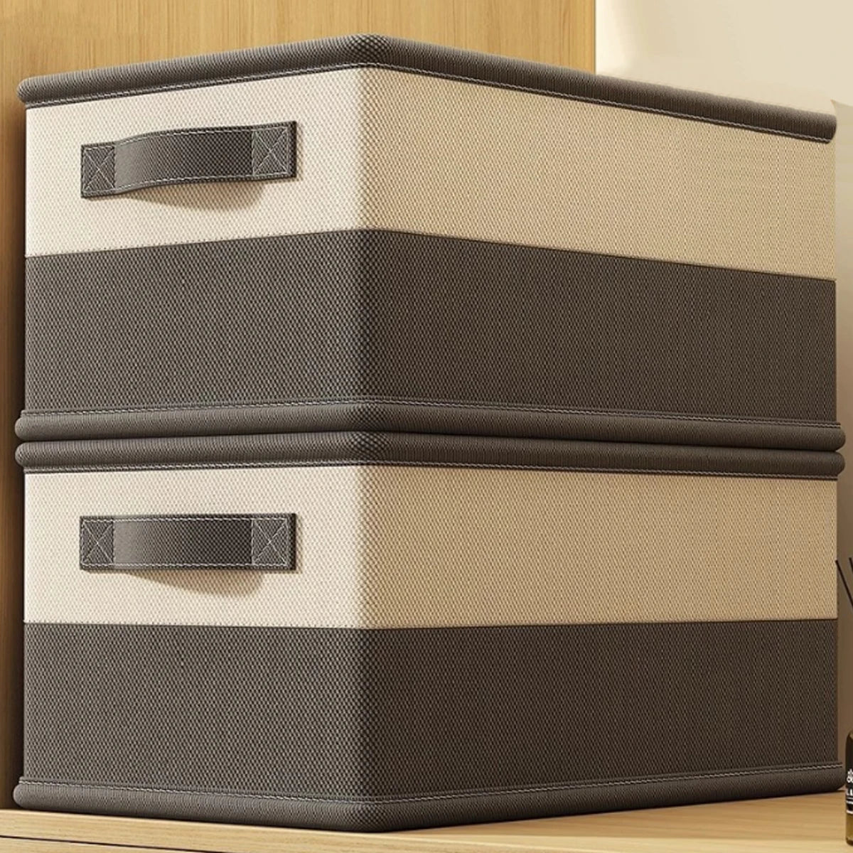 Two storage boxes with brown and beige striped design on a wooden surface.
