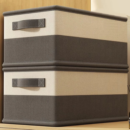 Two storage boxes with brown and beige striped design on a wooden surface.