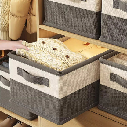 Person reaching into a storage bin filled with knitted items on a wooden shelf.