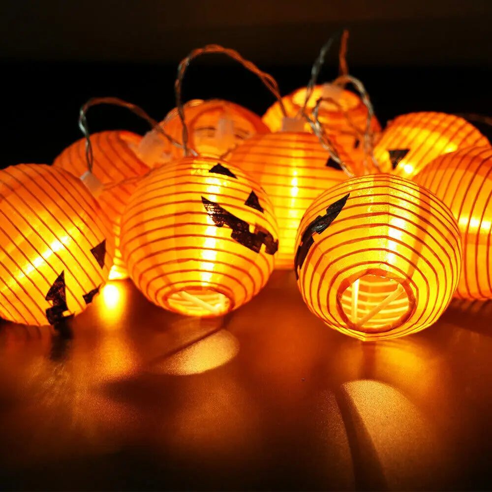 String of Jack-o'-lantern lanterns with carved faces on a dark background