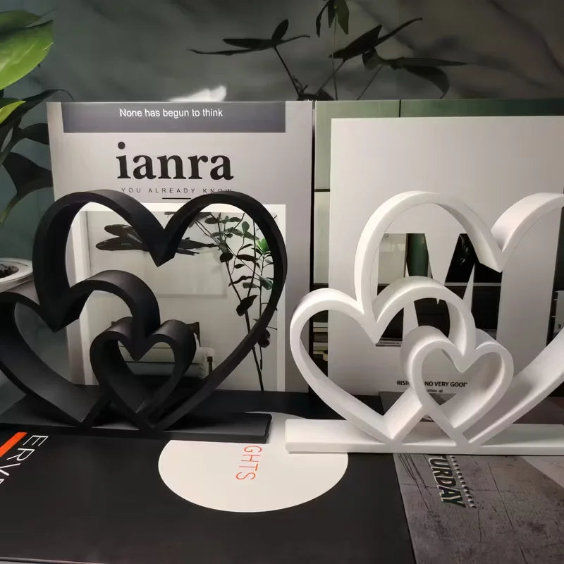 Black and white heart-shaped bookends on a surface with 'ianra' branding in the background.