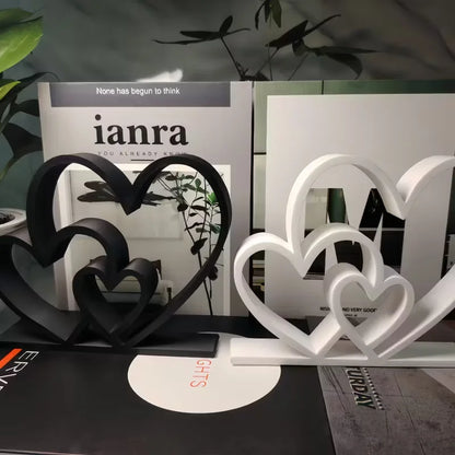 Black and white heart-shaped bookends on a surface with 'ianra' branding in the background.
