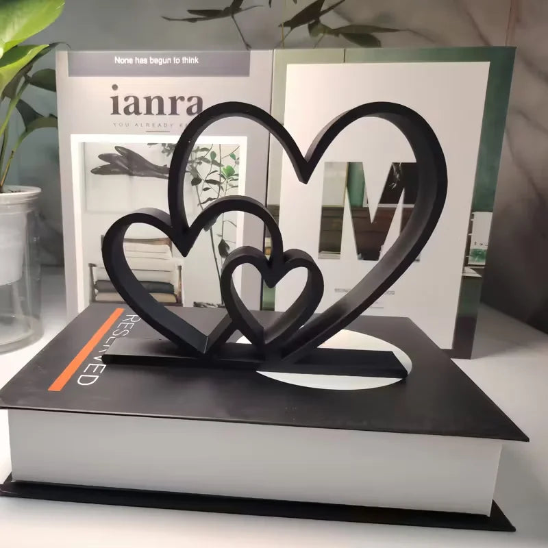 Black heart-shaped bookend on a book with 'ianra' magazine in the background