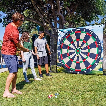People playing darts outdoors with a large dartboard in the background
