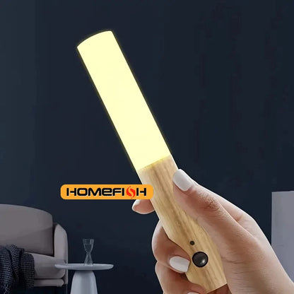 Hand holding a wooden light bar with 'Homefion' branding against a dark background