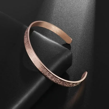 Rose gold bracelet with intricate design on a dark surface
