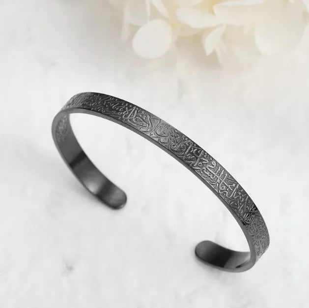 Black metal bracelet with engraved design on a white background
