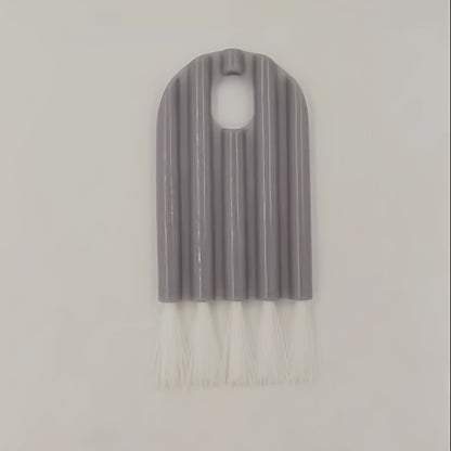 Gray brush with white bristles on a light gray background