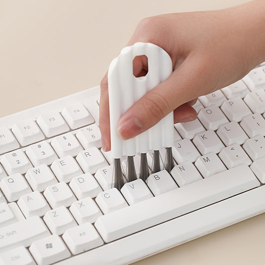 Hand using a white keyboard cleaning tool on a white keyboard.