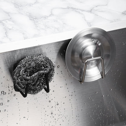 Metallic scrubber and lid lock on a metallic surface with water droplets.
