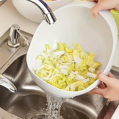 Person washing vegetables in a white colander under running water in a kitchen sink.
