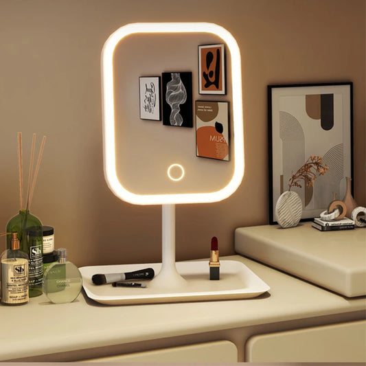 Lighted vanity mirror on a dresser with various items including makeup and decor.