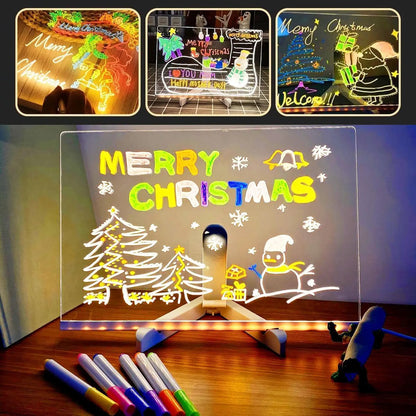 Transparent board with Christmas drawings and text, illuminated by LED lights, on a wooden surface.