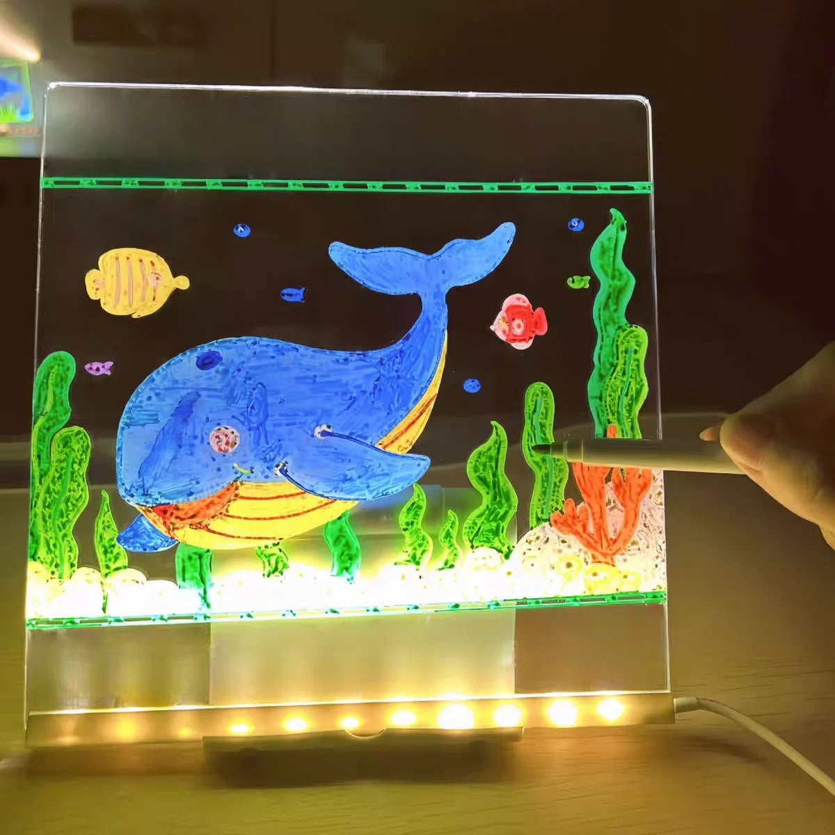 Colorful underwater scene with a whale on a transparent board, illuminated by LED lights.