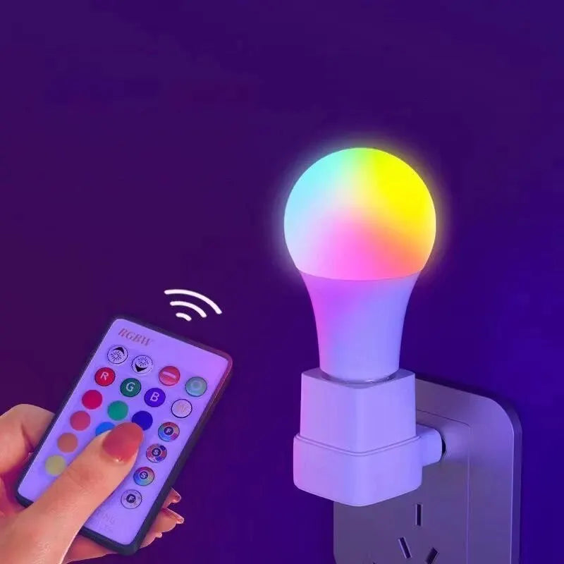 Colorful light bulb connected to a wall socket with a remote control on a dark background