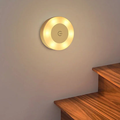 Round wall light fixture on a plain wall with a wooden shelf below.
